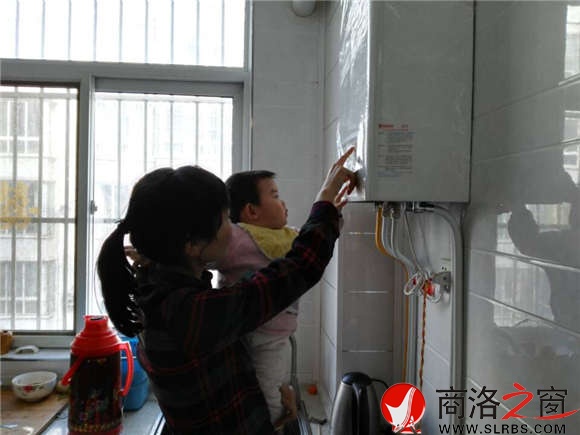 家住市區(qū)香菊小區(qū)的李女士正在操作自家剛剛安裝的燃氣壁掛爐，提升室內(nèi)的溫度。